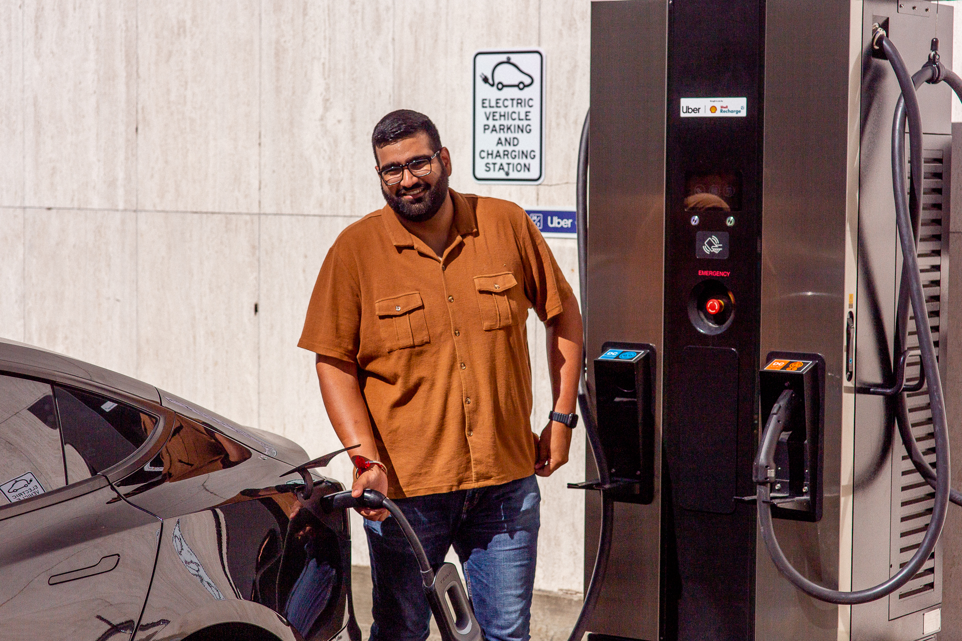 Guy charging an electric vehicle.