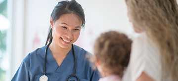 Smiling nurse with mother and child