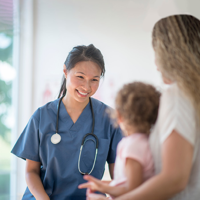 Smiling nurse with mother and child