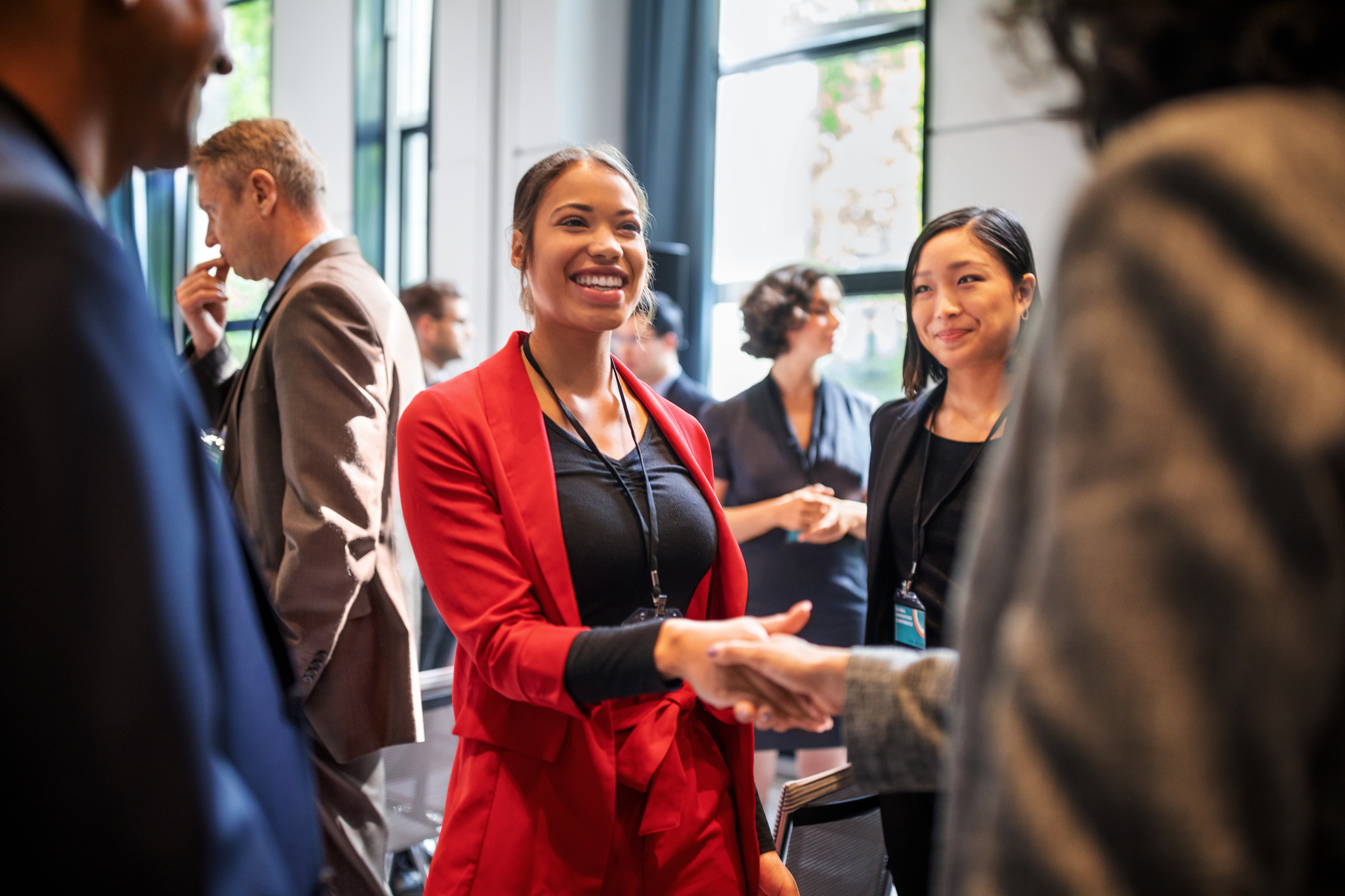 Smiling lady shaking hands with other people