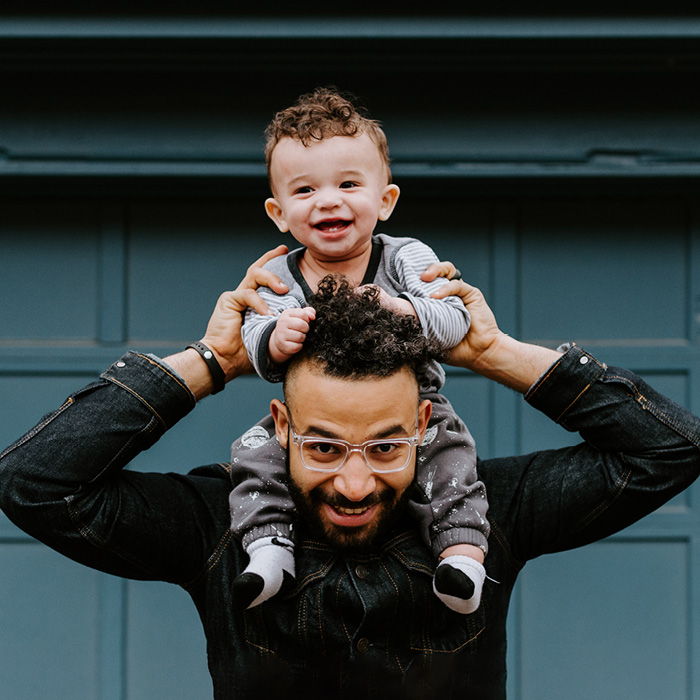 Happy dad carrying happy kid on shoulders