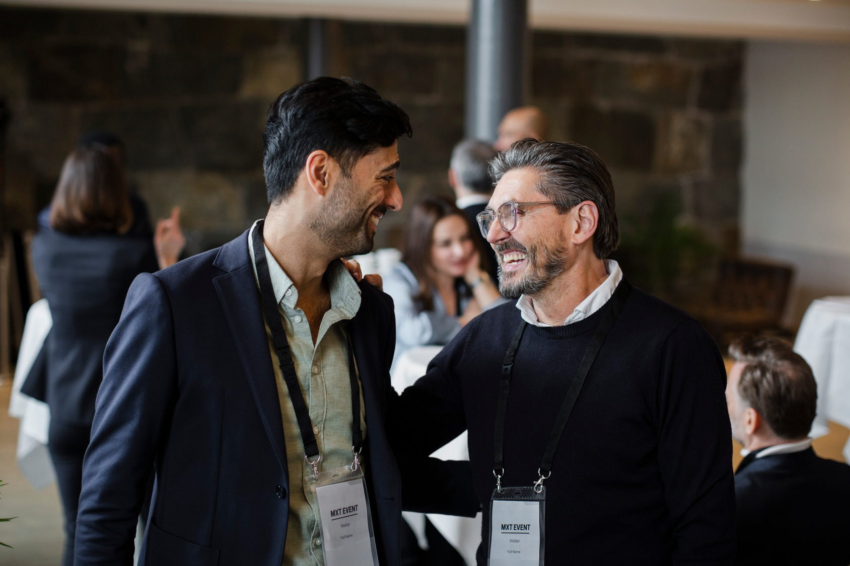 2 men talking and laughing at an event