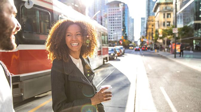 Two people chatting while crossing downtown street