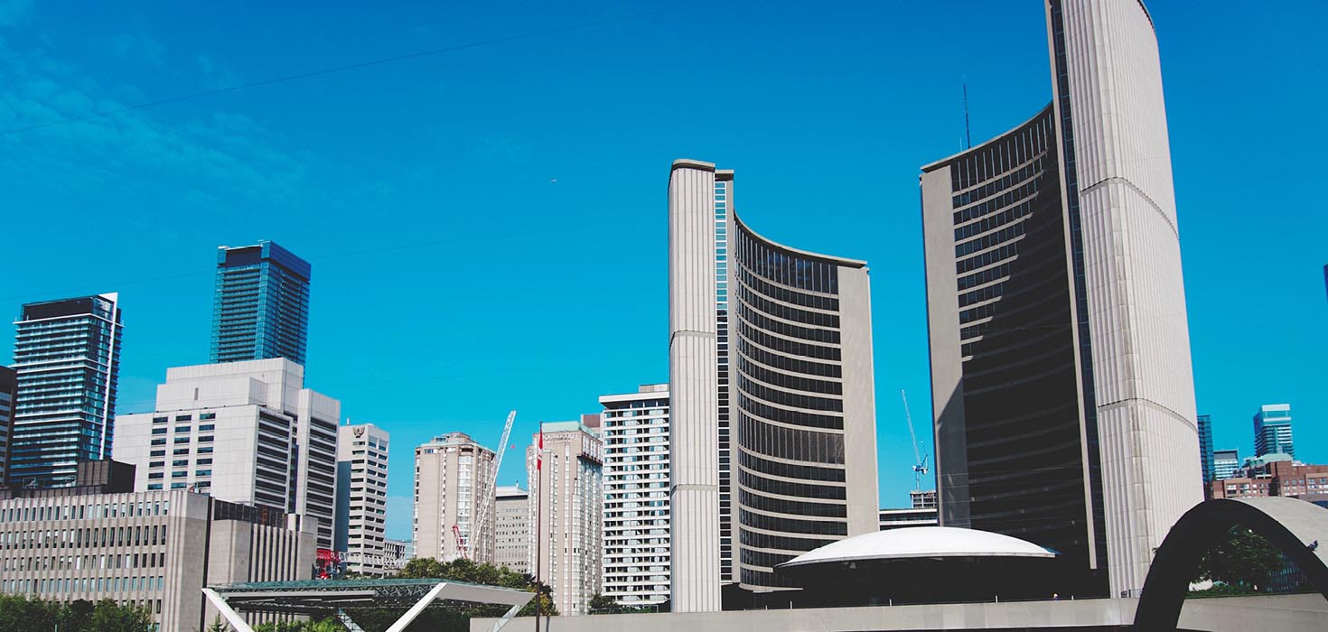 Toronto City Hall in front of a blue, clear sky.