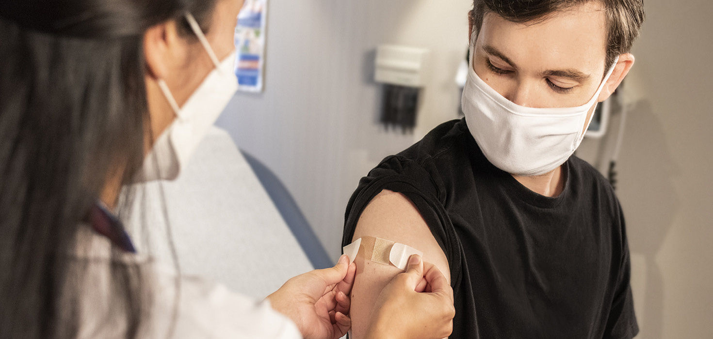 A man getting vaccinated by a healthcare professional.