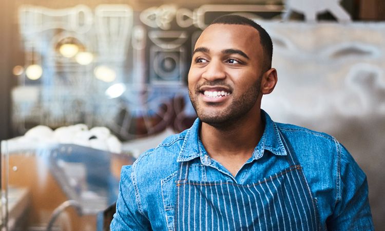 Smiling man with apron on.