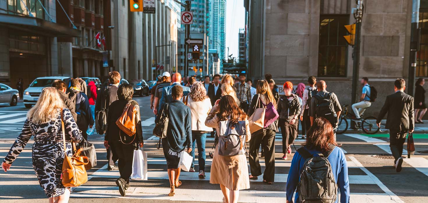 People crossing at a light at a busy downtown intersection.