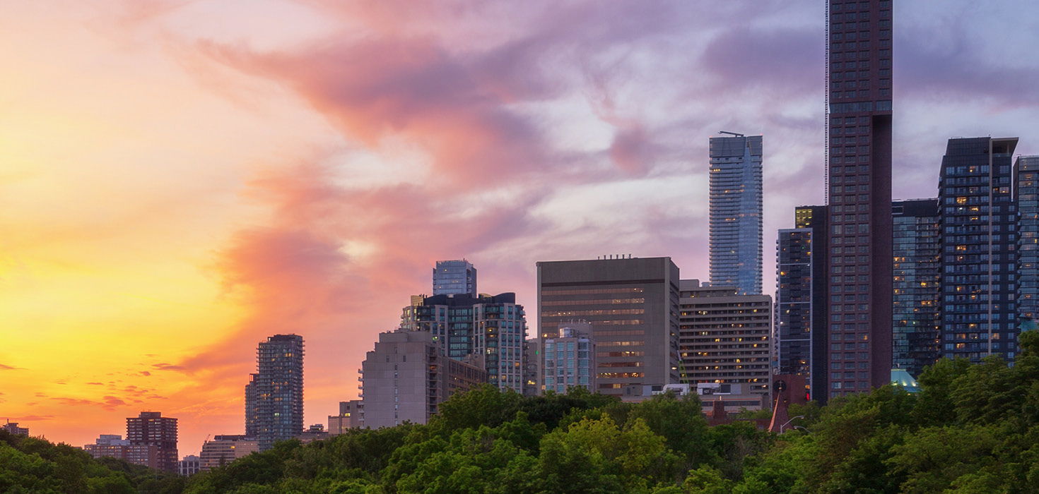 The sun setting alongside multiple high rise condos.