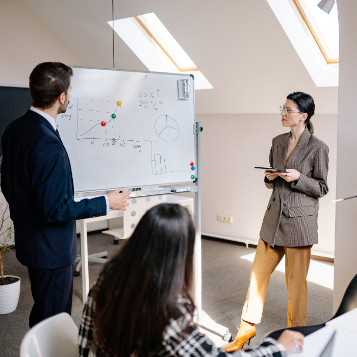 People gathering around a whiteboard, planning.