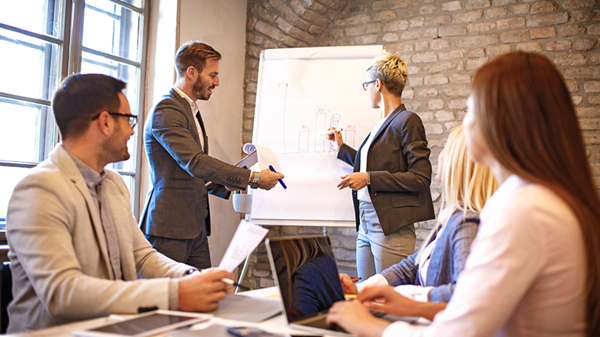 People working together at a whiteboard.